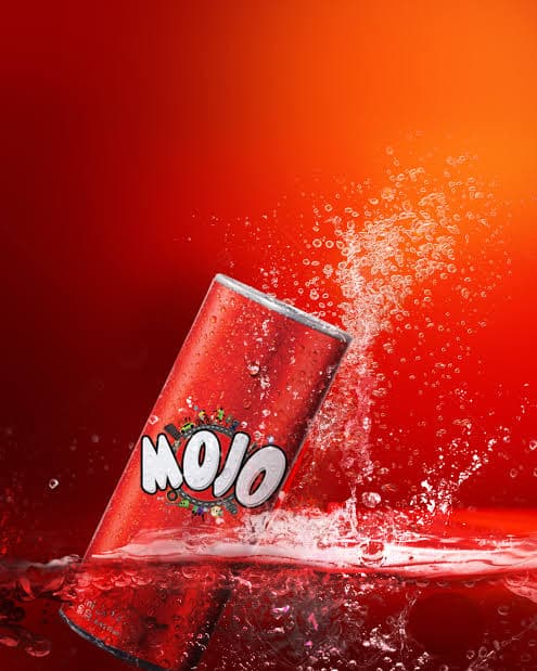 A chilled red MOJO cola can rising out of a cola splash with ice and bubbles.